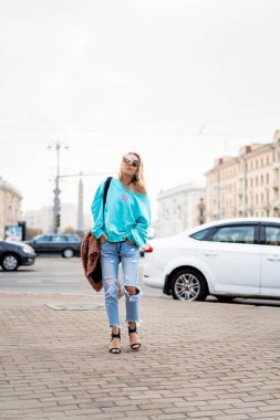 Sonbahar şehrinde saçları olan genç ve güzel bir kadın. Kentsel 