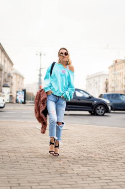 Sonbahar şehrinde saçları olan genç ve güzel bir kadın. Kentsel 