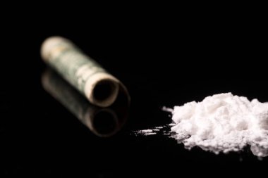 Siyah parlak arka planda izole edilmiş, tüp yoluyla koklanan kokain veya diğer yasadışı uyuşturucular