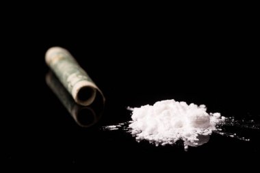 Siyah parlak arka planda izole edilmiş, tüp yoluyla koklanan kokain veya diğer yasadışı uyuşturucular