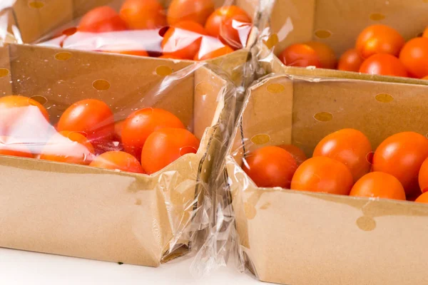 Paquetes de tomates cherry maduros en caja y plástico —  Fotos de Stock