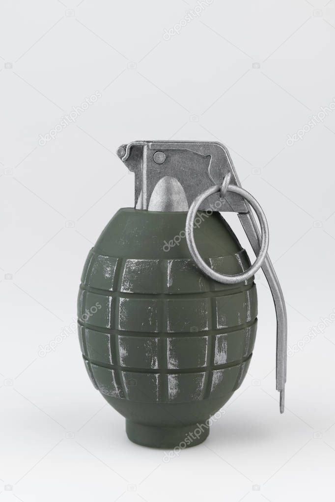 Green metal hand grenade against a white background