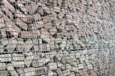 Beton tuğlalardan ve metal örgülerden yapılmış taş duvar.