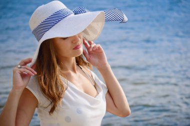 Arka plan dalgalar üzerinde şapkalı güzel bayan. Sıcak vintage renk sınıflandırma ve film bak