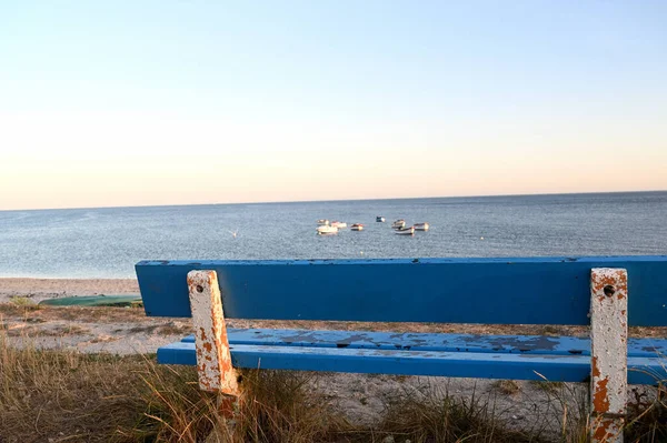 Prázdná dřevěná modrá lavička na pobřeží — Stock fotografie