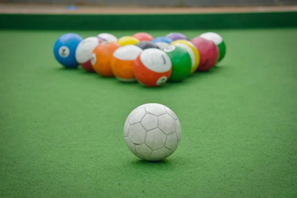 Toplar üçgen şeklinde dizilmiş, futbol bilardosuna hazır.