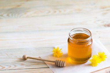Karahindiba reçeli, tatlım, ahşap bir masada cam bir kavanozda şerbet, taze karahindiba çiçekleri, ilaç, sağlıklı yiyecekler, doğadan sağlığa yararlı şeyler. Seçici odak