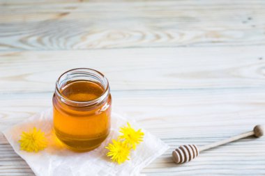 Karahindiba reçeli, tatlım, ahşap bir masada cam bir kavanozda şerbet, taze karahindiba çiçekleri, ilaç, sağlıklı yiyecekler, doğadan sağlığa yararlı şeyler. Seçici odak