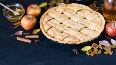 Olgun elmalı ev yapımı elmalı turta, türler ve sonbahar yaprakları koyu kırsal ahşap masa üzerinde, yatay yönelim, seçici odak