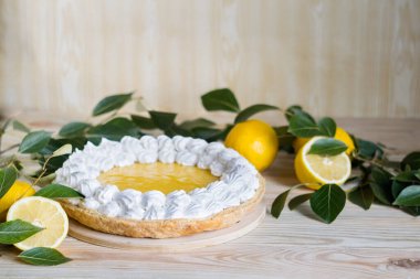 Açık ahşap arka planda kremalı taze ev yapımı limonlu turta, seçici odaklı.