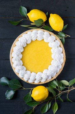 Siyah ahşap arka planda taze limonlu ev yapımı limonlu turta..