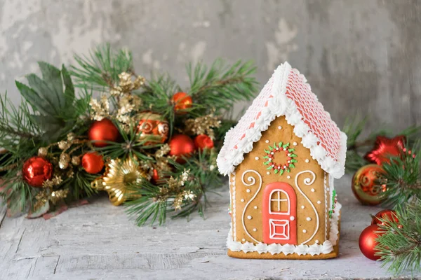 Kırsal ahşap masa üzerinde noel süsleri olan zencefilli kek evi, seçici bir odak noktası. Yatay yönelim.