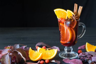 Ahşap arka planda sıcak şarap ve baharatlar. Seçici odak.