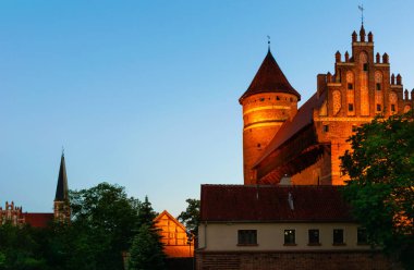 Olsztyn şafakta. Ön planda -Olsztyn'deki Warmian Bishops Kalesi. Arka planda - Polonya Our Lady Queen Garnizon Kilisesi