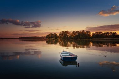 Rowing boat floating over the Elckie Lake waters. Masuria, Poland. clipart