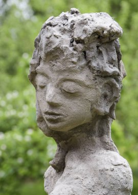 betondan yapılmış bir bahçe heykelinin yakın yüzü, kapalı gözlü çocuk heykeli, dikey