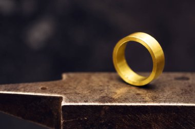 altın yüzük takı fabrikada goldsmith örs üzerinde atış kopya alanı koyu arka plan, seçilen odak, dar alan derinliği ile yakından