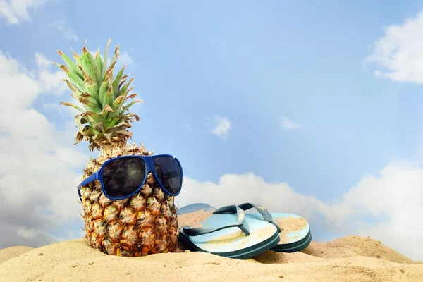 ananas meyve ile güneş gözlüğü ve flip flop sandal sahilde kum mavi gökyüzü bulutlu, yaz tatil kavramı, karşı kopyalama alanı, seçili odak