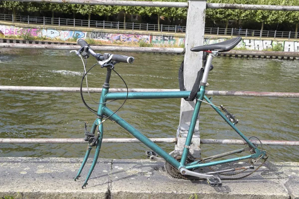 壊れた自転車輪なし接続の橋の欄干にロック ポイ捨てや都市の破壊行為の概念 — ストック写真