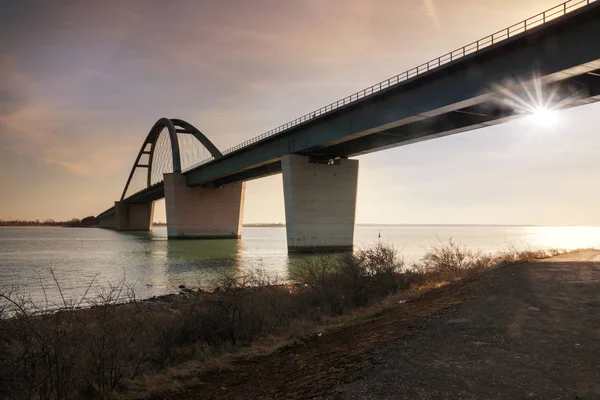 日没のフェーマルン音橋 ドイツ語 Fehmarnsundbruecke 鋼吊橋のバルト海の島とドイツ本土を結ぶアーチ Vogelfluglinie 選択したフォーカスに属して — ストック写真