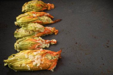 pişmiş kabak dolması veya kabak çiçekleri üst üste bir karanlık fırın tepsisi, kopya alanı, seçilen odak, dar alan derinliği parmesan peyniri ile