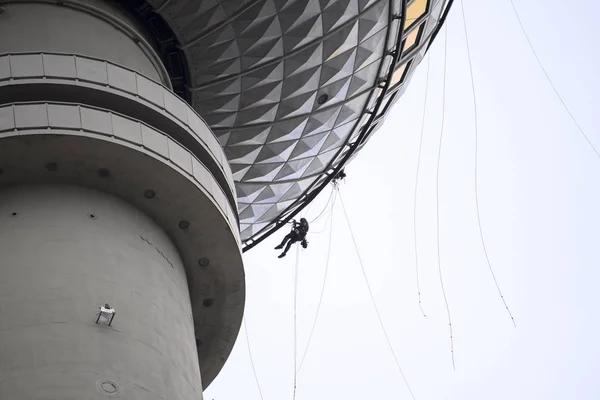 登山家がベルリン コピー スペースで有名なテレビ塔でロープにぶら下がっている都市登山 Buildering — ストック写真