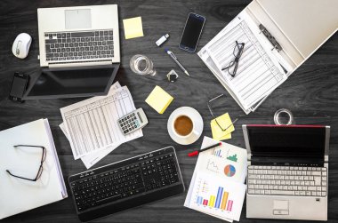 gri ofis masası toplantısında bir iş dizüstü bilgisayarlar, telefonlar ve finansal belgeler, yukarıdan yüksek açılı görünüş