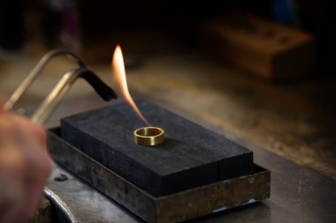 altın yüzük takı fabrikası, koyu arka plan, seçilen odak, dar alan derinliği kopya alanı içinde bir gaz alev ile komplementer olan