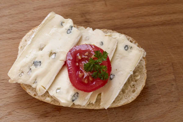 木の板 上から上面にモールド チーズ トマト パセリを飾るとロールパンがフォーカスを選択 — ストック写真