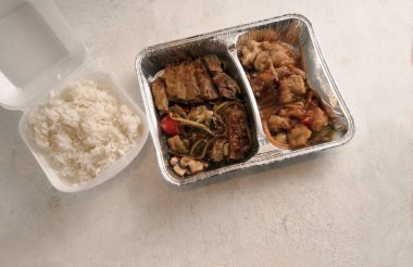 Asya Lokanta teslimat hizmeti bir folyo kapta ve pirinç bir köpük kutusunda parlak bir arka plan, yukarıdan, kopya alanı, seçilen odak yüksek açılı görünüş