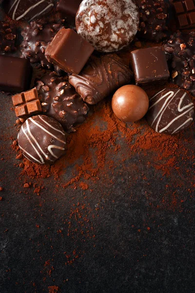 お祝いのチョコレート クッキーとスレート石の上にプラリネ スラブ 暗い背景上からハイアングル寛大なコピー スペースと垂直 — ストック写真