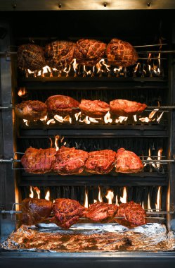 Belgili tanımlık Noel çarşı içinde Mantova, Almanya, dikey, açık bir yangın büyük şiş üzerinde domuz rostosu ızgara