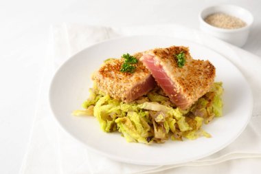 Susam beyaz masa, kopya alanı, seçilen odak, dar alan derinliği bir tabakta savoy lahana sebze ile kavrulmuş orkinos biftek