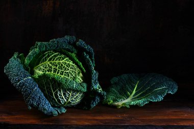 yeşil savoy lahana, tüm baş ve kopya alanı, karanlık ve huysuz rustik ahşap bir yaprağına odak seçili