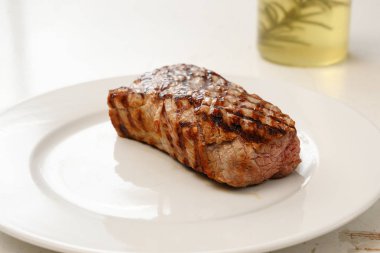 kavrulmuş Dana fileto, beyaz tabak, biberiye yağı dar alan derinliği arka plan, kopya alanı, seçilen odak içinde genç sığır eti