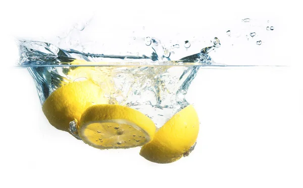 Rodajas de limón caen al agua con salpicadura, aislado sobre un fondo blanco, espacio de copia — Foto de Stock