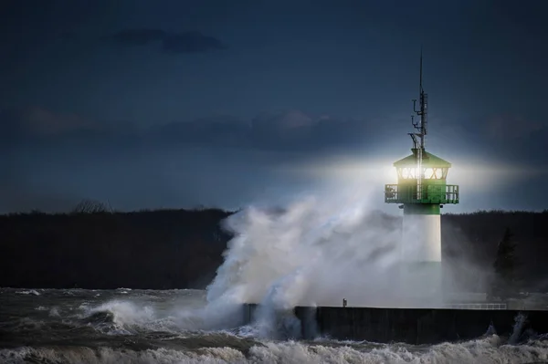 Vuurtoren tijdens storm in spetterend spray's nachts aan de Baltische Zee, Travemünde in de baai, Luebeck kopiëren ruimte — Stockfoto