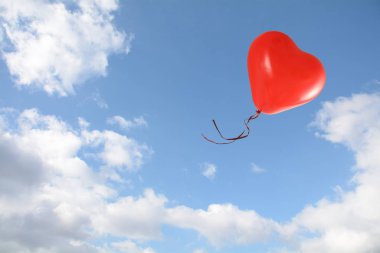mavi gökyüzünde bulutlar, aşk kavramı ile kırmızı kalp şeklinde balon uçar