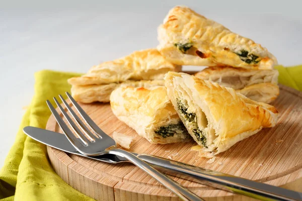 Puff pastry filled with spinach and ricotta on a wooden kitchen board — Stock Photo, Image