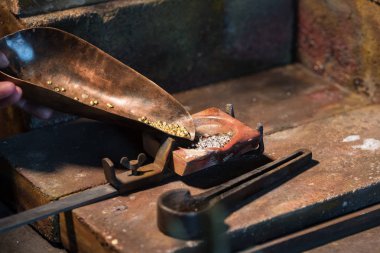 bir alaşım takı araçları Kuyumculuk işyerinde, erime için bir pota içinde altın ve gümüş granül alanı Kopyala