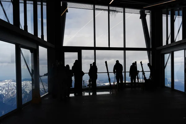 Ludzie z nartami, jak sylwetki czekać na stacji kolei linowych lub kolejki linowej na gondolę na Zugspitze, najwyższy szczyt Niemiec w Alpach Bawarskich — Zdjęcie stockowe