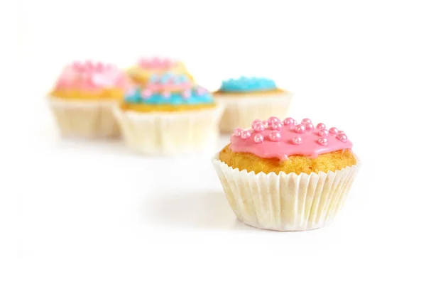 머핀 또는 핑크 아이싱과 설탕 진주와 컵 케이크, 흰색에 그림자로 고립 된 배경에 더 많은 컵 케이크, 복사 공간 — 스톡 사진