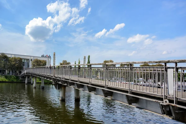 LUEBECK, GERMANIA - 3 GIUGNO 2019: Ponte pedonale sul fiume Trave fino al MUK, Music and Congress Hall, un edificio moderno a Luebeck, copia lo spazio — Foto Stock