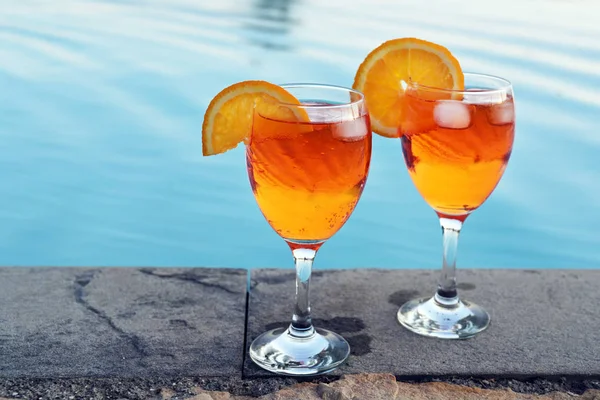 Two glasses Spritz Veneziano, an Italian cocktail drink from aperol, prosecco and soda, served at the pool, copy space — Stock Photo, Image