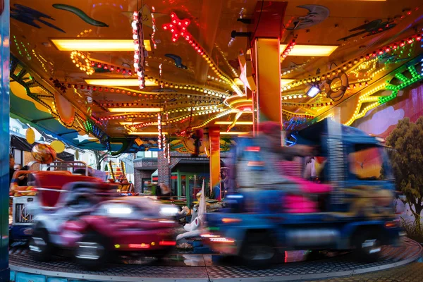 Carrusel del coche de los niños en el mercado de la feria de Navidad, larga exposición ttime con movimiento borroso — Foto de Stock