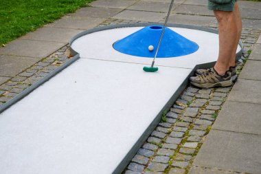 bir engel olarak mavi bir koni ile bir mini golf sahasında bir adamın bacakları, kopya alanı