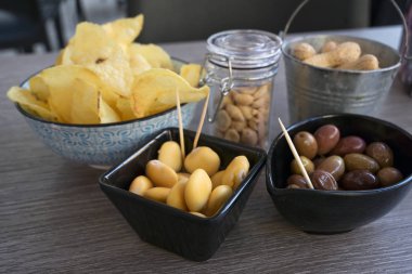fasulye, zeytin, fındık ve cips gibi küçük aperatifler bir açık bistro, seçilen odak, alan dar derinliği bir masada
