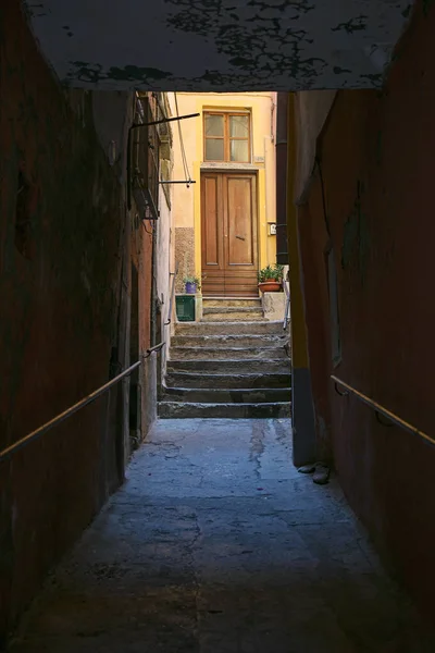 ถนนมืดไปที่ทางเข้าบ้านเมืองเก่าสีเหลืองในอิตาลี โฟกัสที่เลือก ความลึกแคบของสนาม — ภาพถ่ายสต็อก