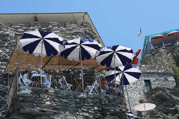 Balcony restaurant on the rocks of the steep coast on the Mediterranean sea against the blue sky in Vernazza, Cinque Terre, Italy — Stock Photo, Image