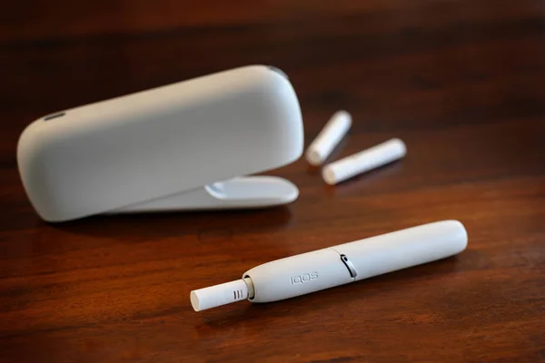 Rieps, deutschland, 15. August 2019: iqos Heiztabakanlage auf braunem Tisch, neue E-Zigarette mit Tabaksticks, die angeblich Schadensminderung bei Rauchern bewirkt, Kopierraum — Stockfoto